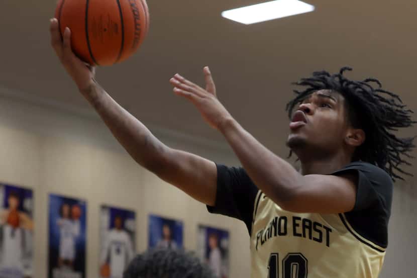 Plano East guard Xavier Miller (10) finishes a fast break with two of his first half points...