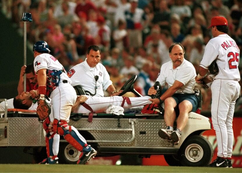 FILE - Rangers first baseman Rafael Palmeiro (25) watches catcher Ivan Rodriguez make a...