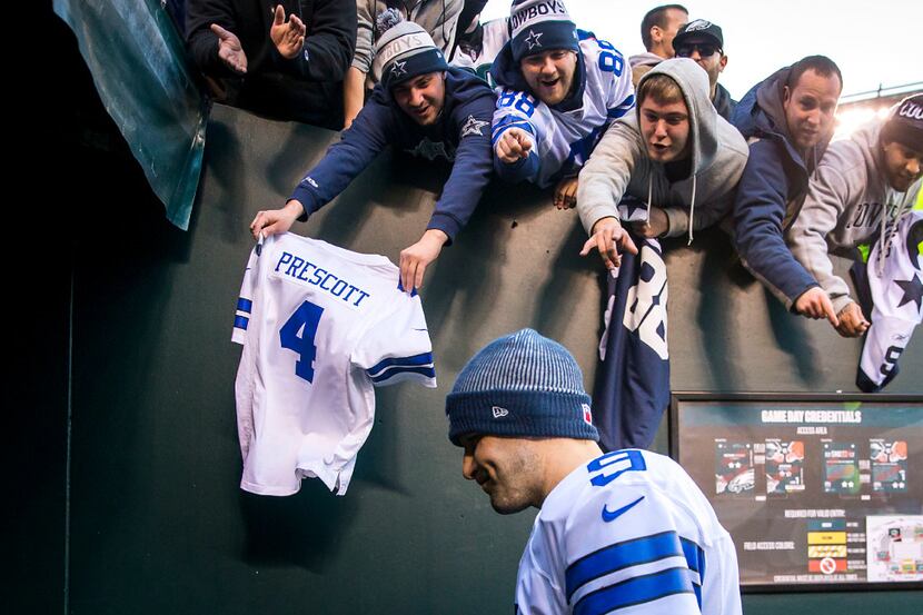 Fans -- including one holding a Dak Prescott jersey -- yell to Dallas Cowboys quarterback...