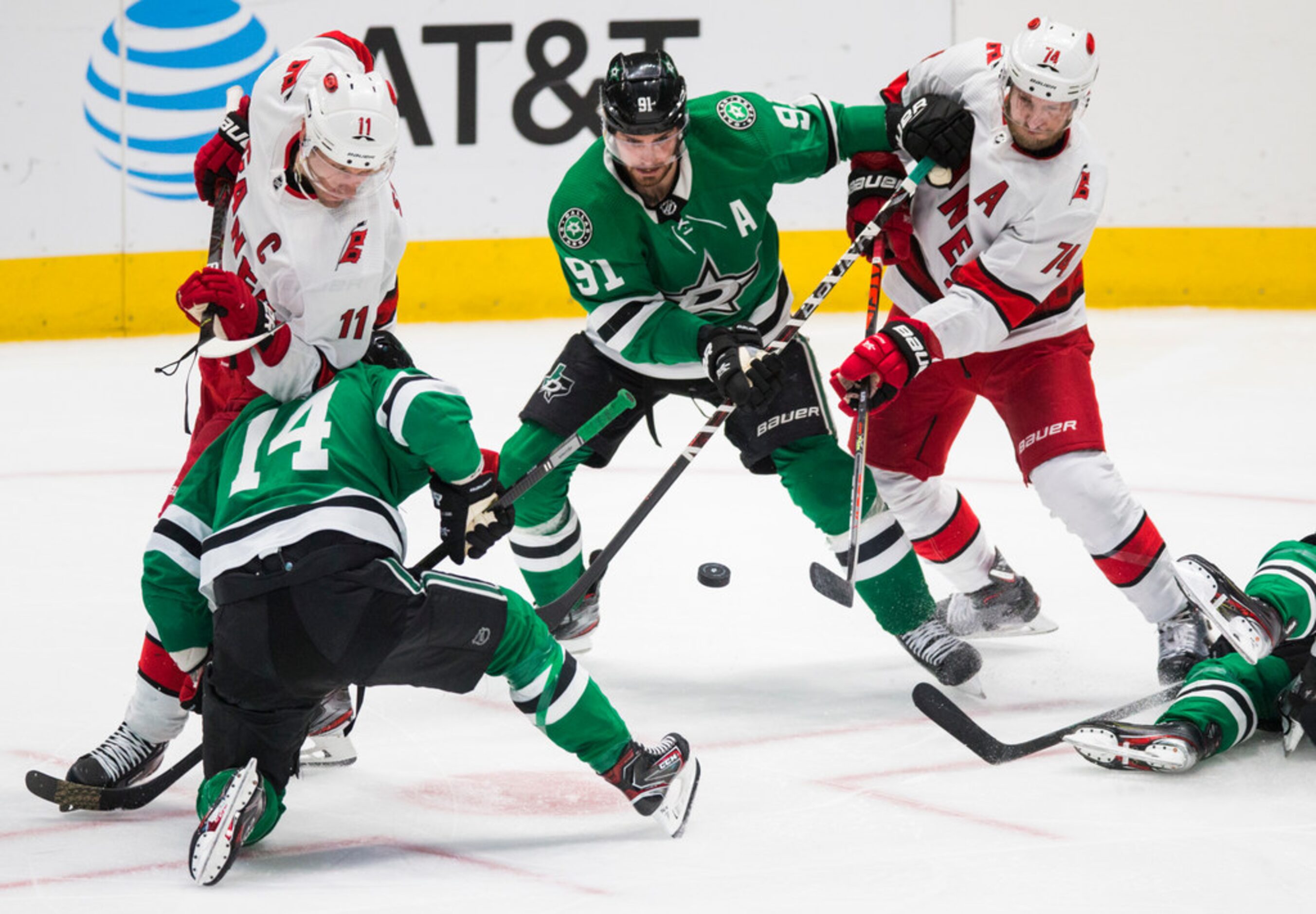 Dallas Stars center Tyler Seguin (91) fights for the puck with Carolina Hurricanes...