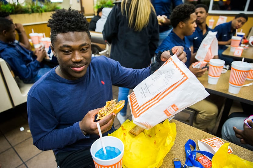Lone Star High School football player Darrin Smith, 16, holds up the receipt for his triple...