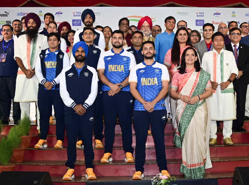 Indian athletes posing with officials model India's ceremonial and playing uniforms for the...