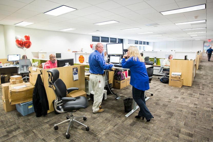 
Workers chat around a standing workstations furnished by Haworth at the Toyota North...