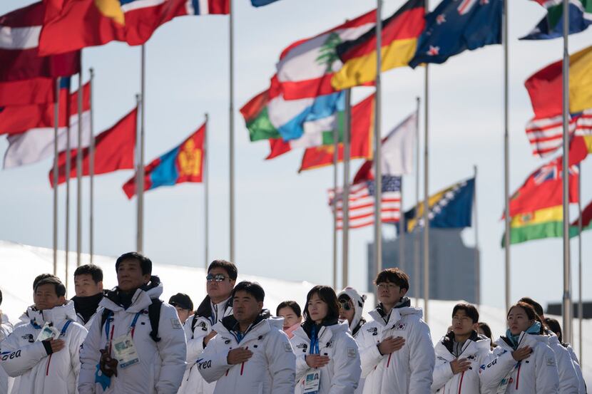 Members of the South Korea Olympic Team listen to their national anthem during a welcome...