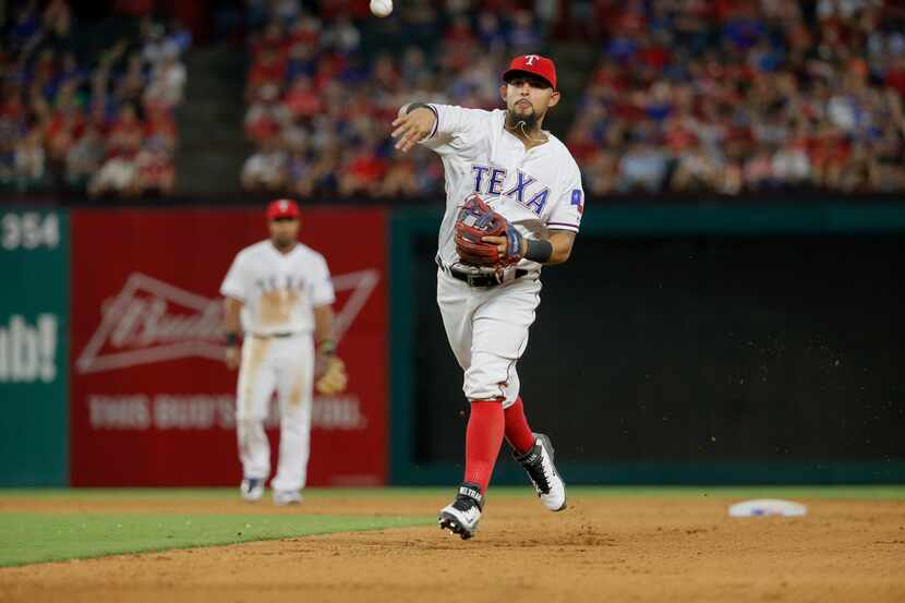 Texas Rangers second baseman Rougned Odor throws to first during a baseball game against the...
