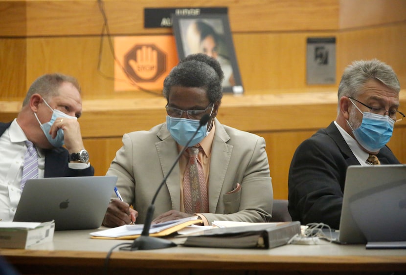 Victor Williams (center) listens as he sits with his defense team during his trial at the...