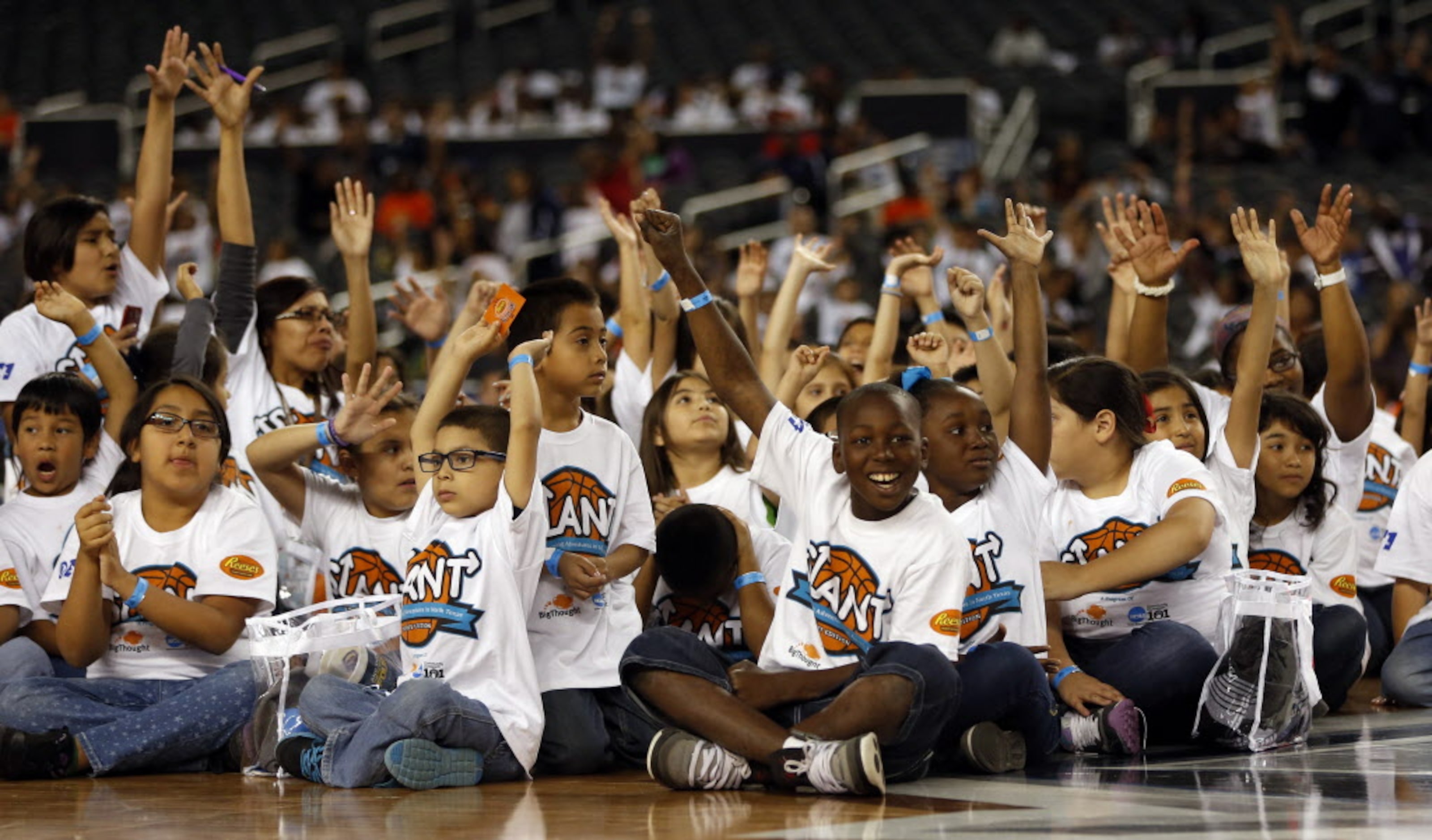 Kids wave during the Reese's Final Four Slant Celebration at AT&T Stadium in Arlington, on...