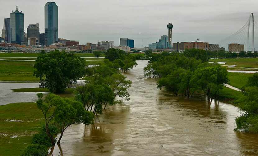 The rain-swollen Trinity River flows past Trammell Crow Park near downtown Dallas on May 12,...