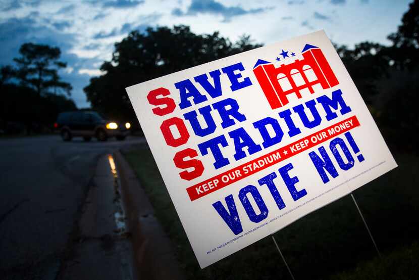 Yard signs expressing opposition to a proposal $1 billion retractable-roof stadium for the...