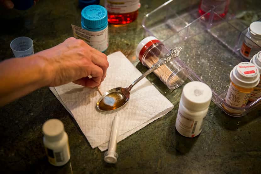 Christy Zartler mixes Kara's morning medications, pills she has crushed into a powder, with...