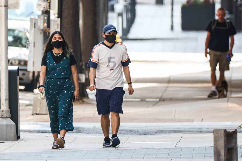 To mask or not to mask: Some pedestrians in downtown Dallas were taking extra precautions...