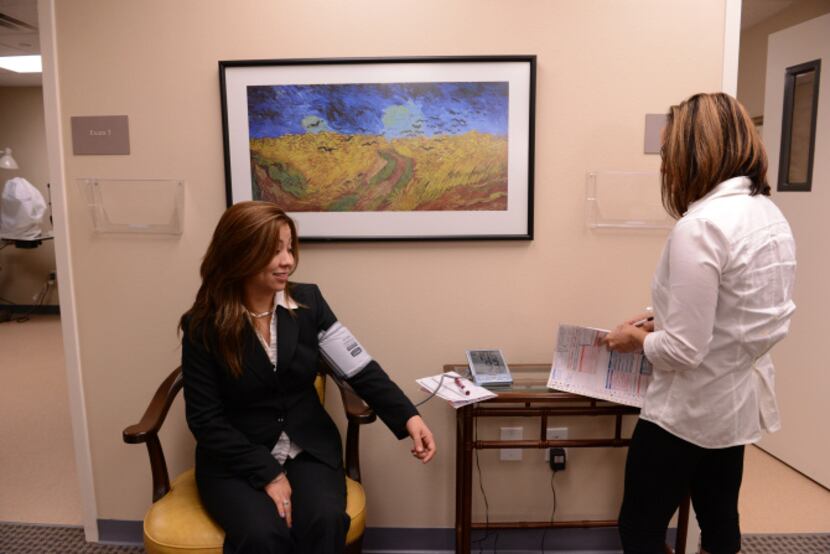 Sandra Tovar gets her blood pressure checked by Julie Dreaden, a nurse at Christ's Family...
