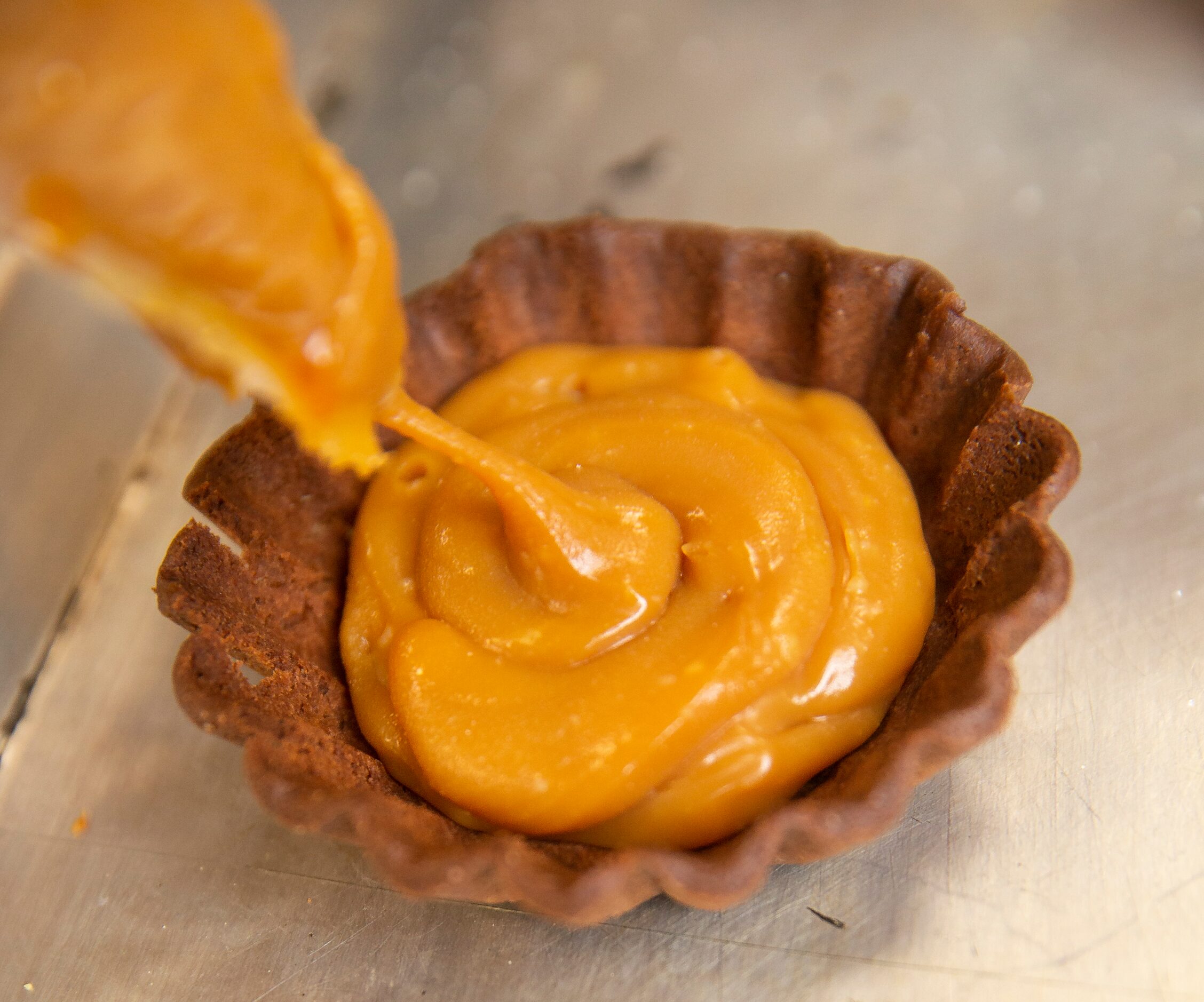 Co-owner Maricsa Trejo prepares a chocolate caramel tart at La Casita Bakeshop on Feb. 12,...