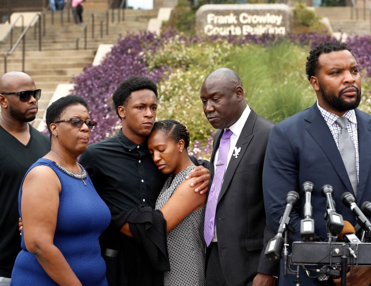 Brandt Jean, brother of shooting victim Botham Jean (third from left), hugs his sister...