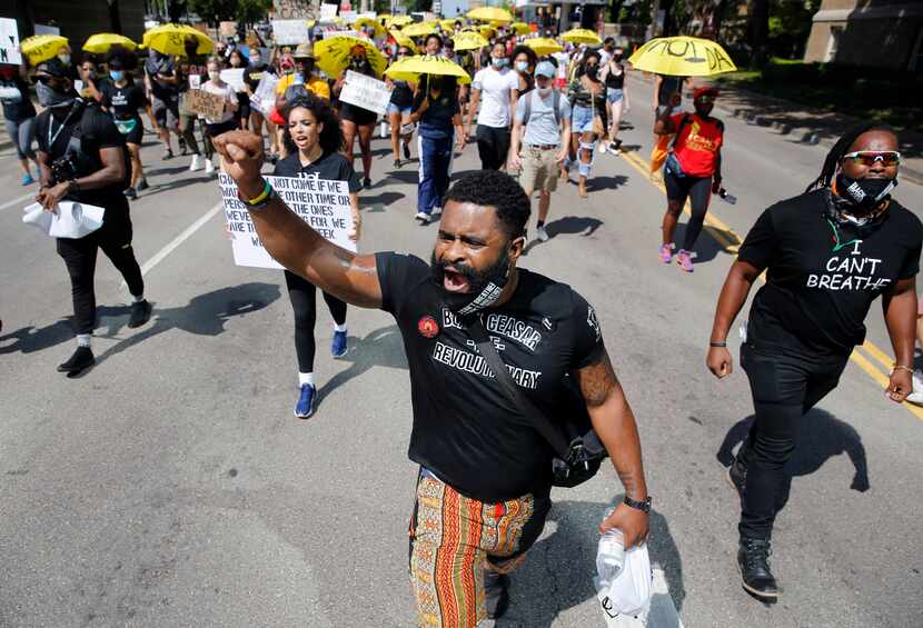 Kristoddie Woods chants with protesters as they march on Ross Avenue in downtown Dallas...