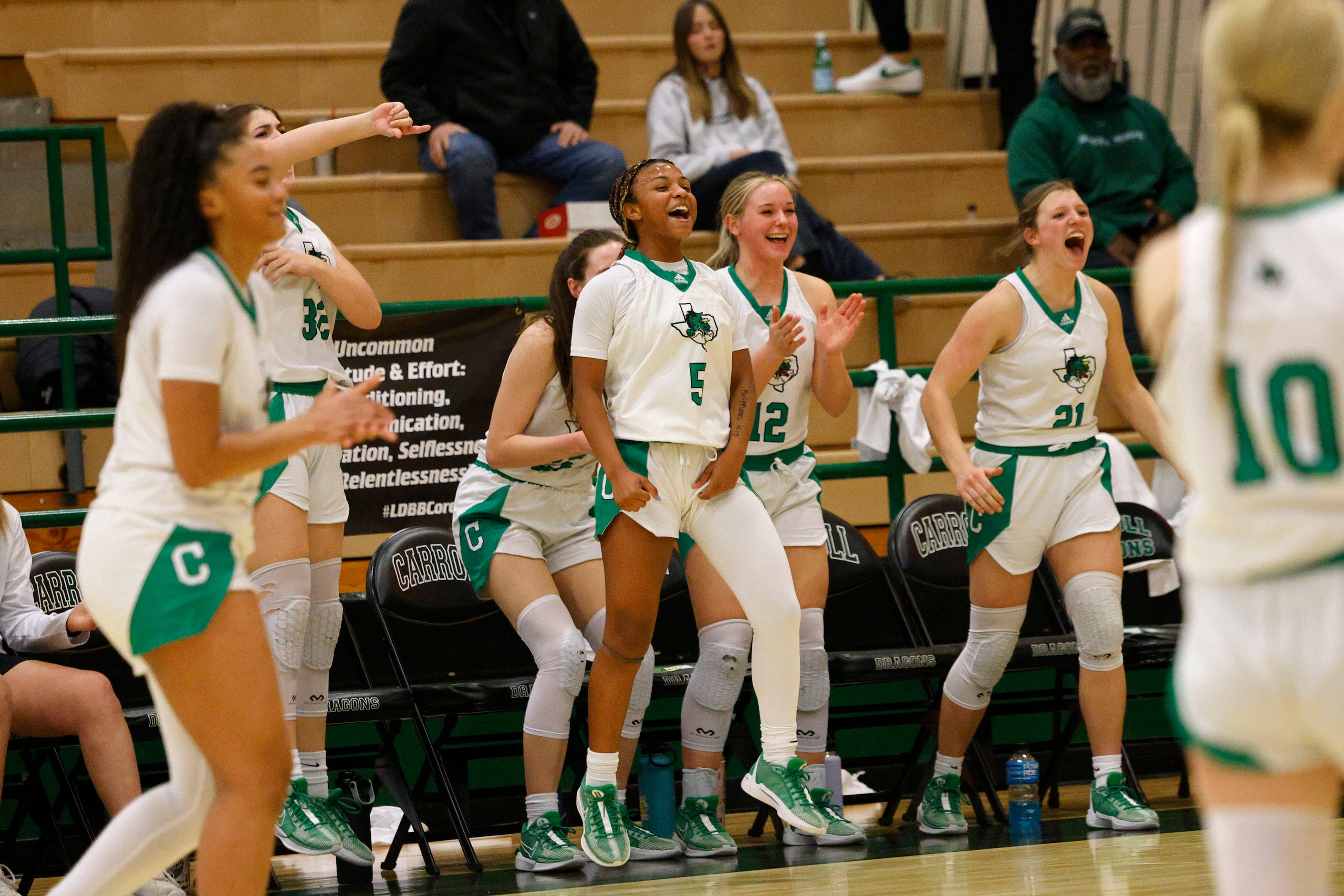 Southlake Carroll’s players cheer during the second half of a high school basketball game...