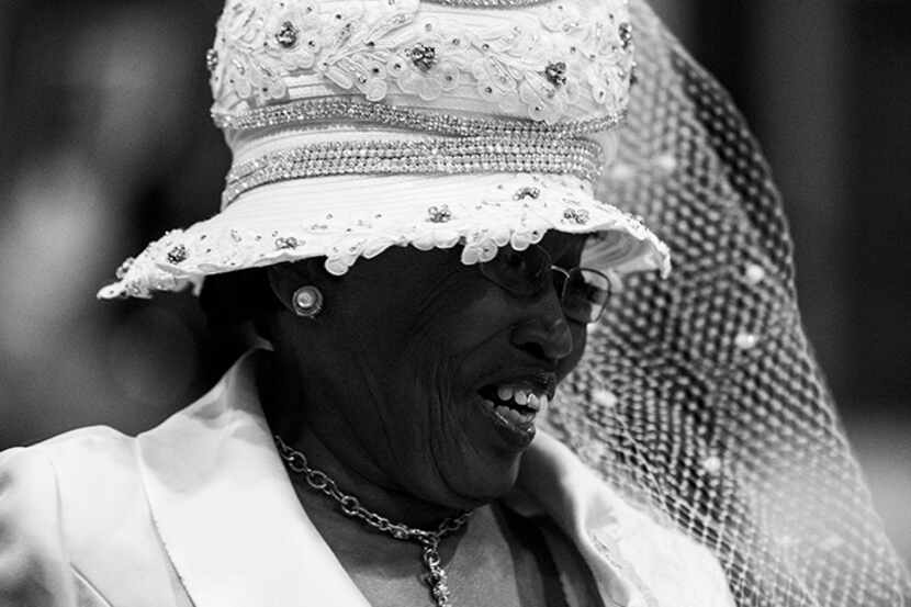  A woman in a white hat smiles during a communion and feet washing service at The National...