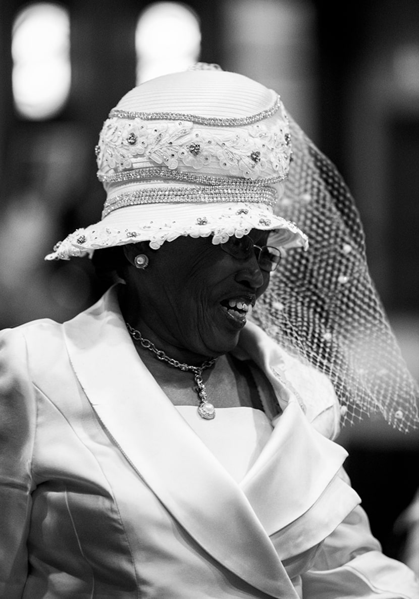  A woman in a white hat smiles during a communion and feet washing service at The National...