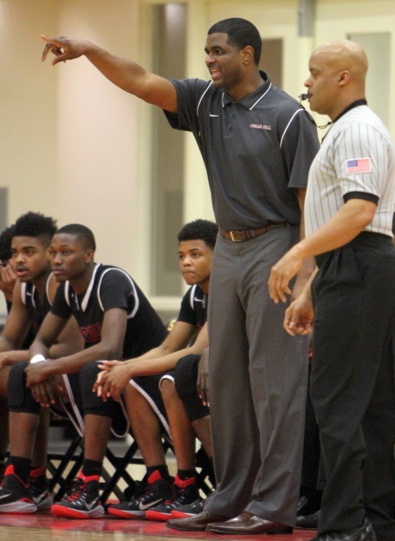 Cedar Hill head coach Brandon Thomas directs his players from the team bench during first...