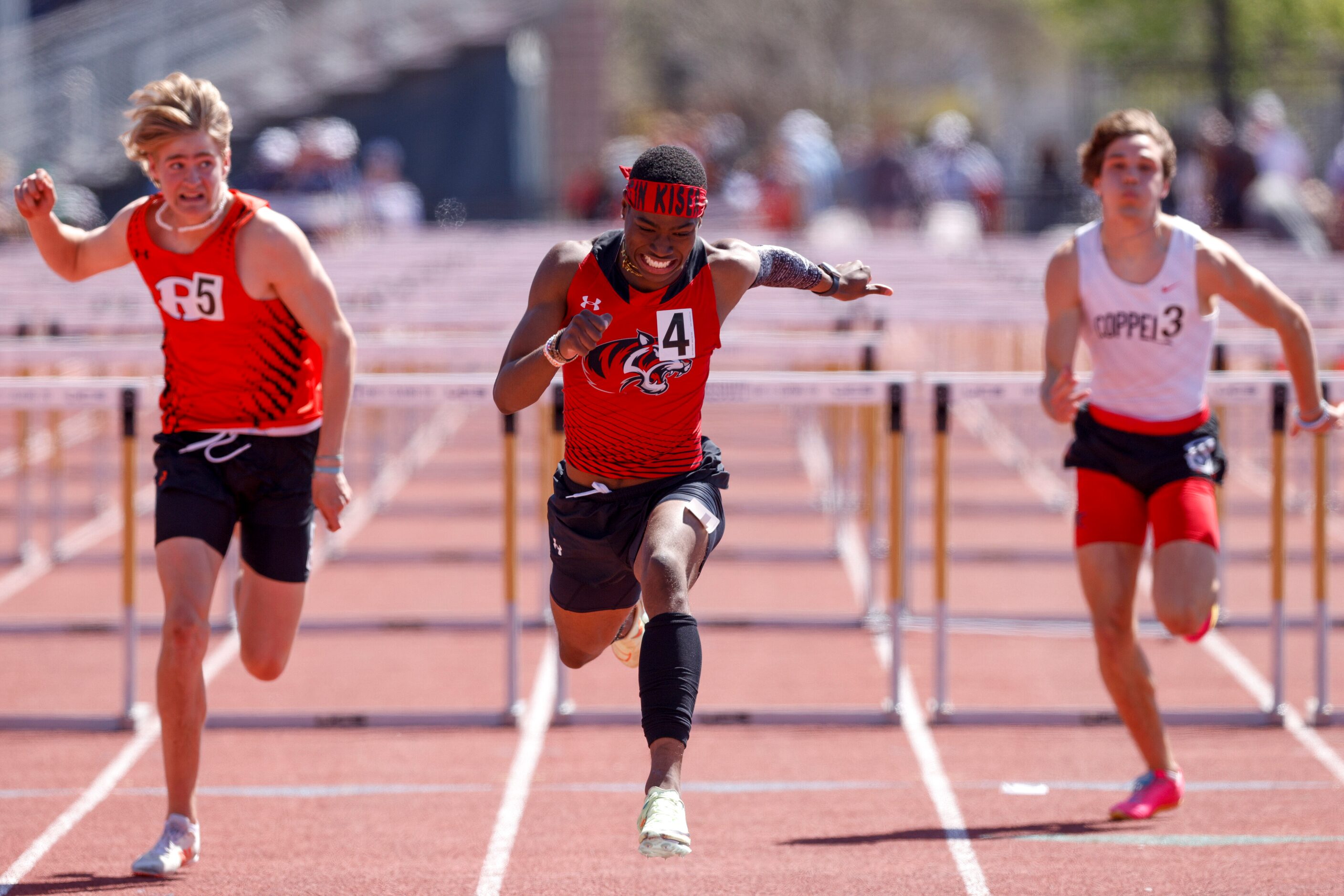 Denton Braswell’s Austin Kiser (center) stretches across the finish line ahead of Rockwall’s...