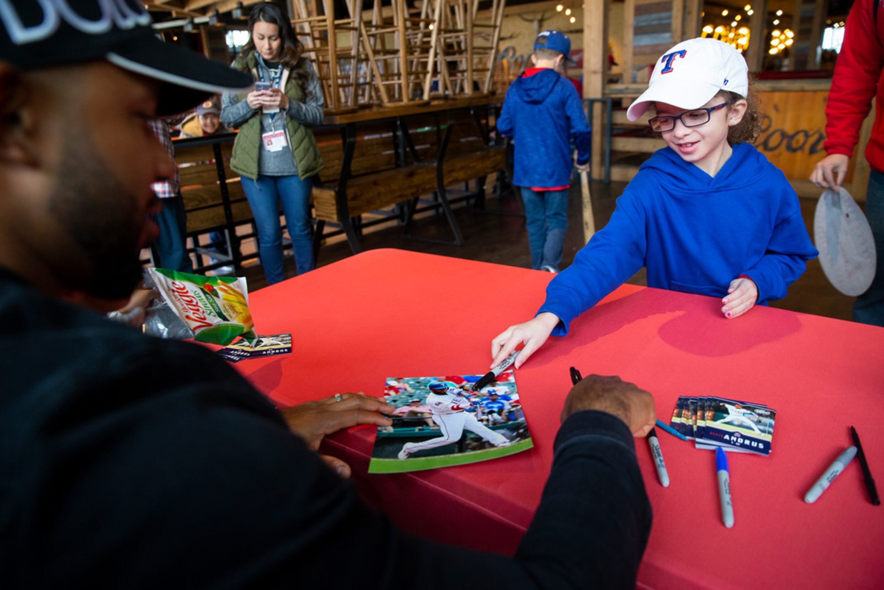 Bevin Thorpe, 8, from Forney gives Texas Rangers shortstop Elvis Andrus (1) a photo to sign...