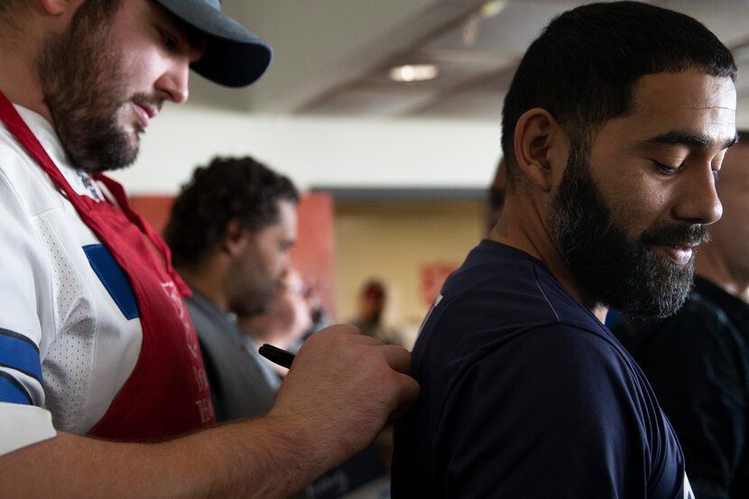 Dallas Cowboys offensive guard Zack Martin (left) signs the jersey worn by Juan Teniente...