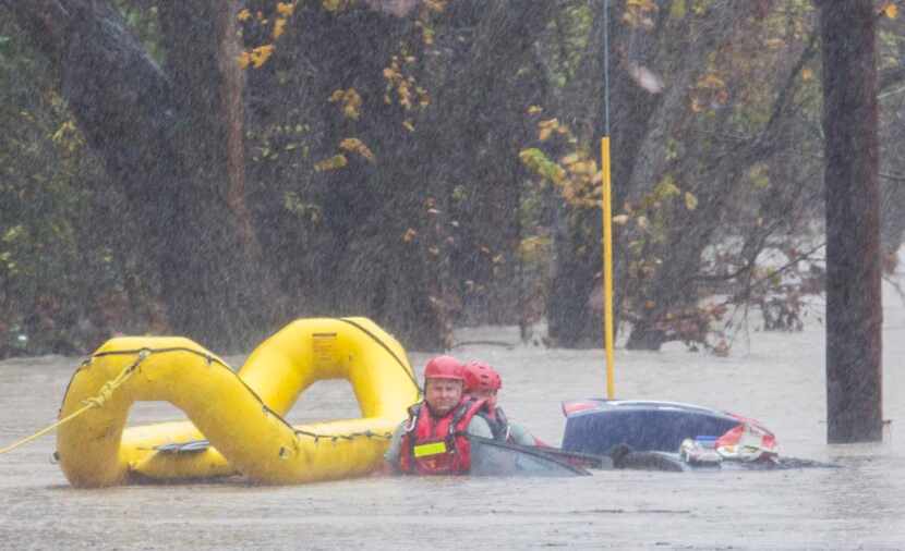 
Garland Fire Department rescue teams tended to a vehicle submerged in floodwaters Friday...