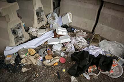  Trash left behind in a homeless encampment off Coombs Street Wednesday, May 11, 2016 in...