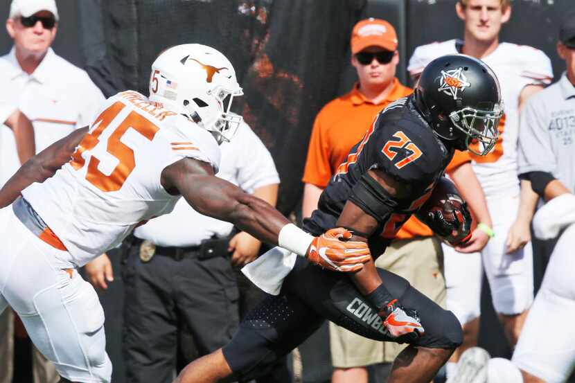 Oklahoma State running back Justice Hill (27) gets past Texas linebacker Anthony Wheeler...
