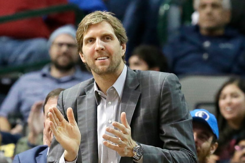 Dallas Mavericks forward Dirk Nowitzki of Germany claps for his teammates while watching...