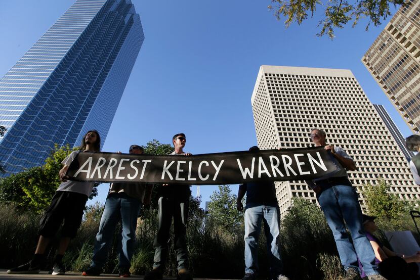 Protesters hold a sign calling for the arrest of Dallas based Energy Transfer Partners CEO...