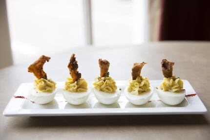 The deviled eggs come topped with crispy chicken skin, chives and smoked paprika.