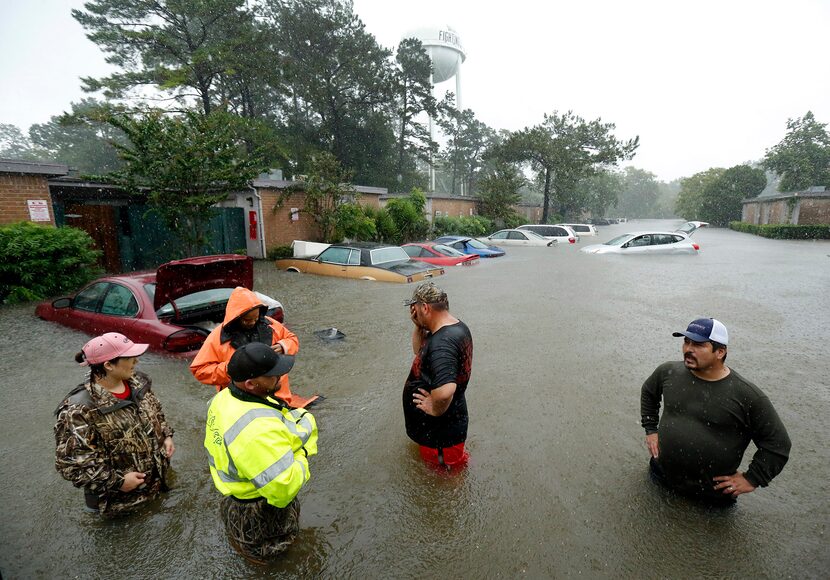 Local volunteers including Christina Crump (left) and her husband Aaron Crump (foreground),...