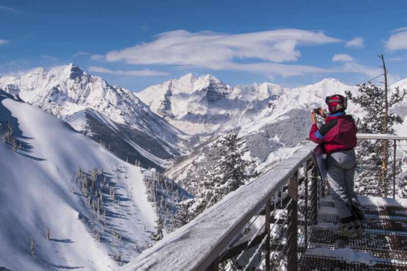 A skier captures the view of Pyramid Peak and the Maroon Bells from the deck of the ski...