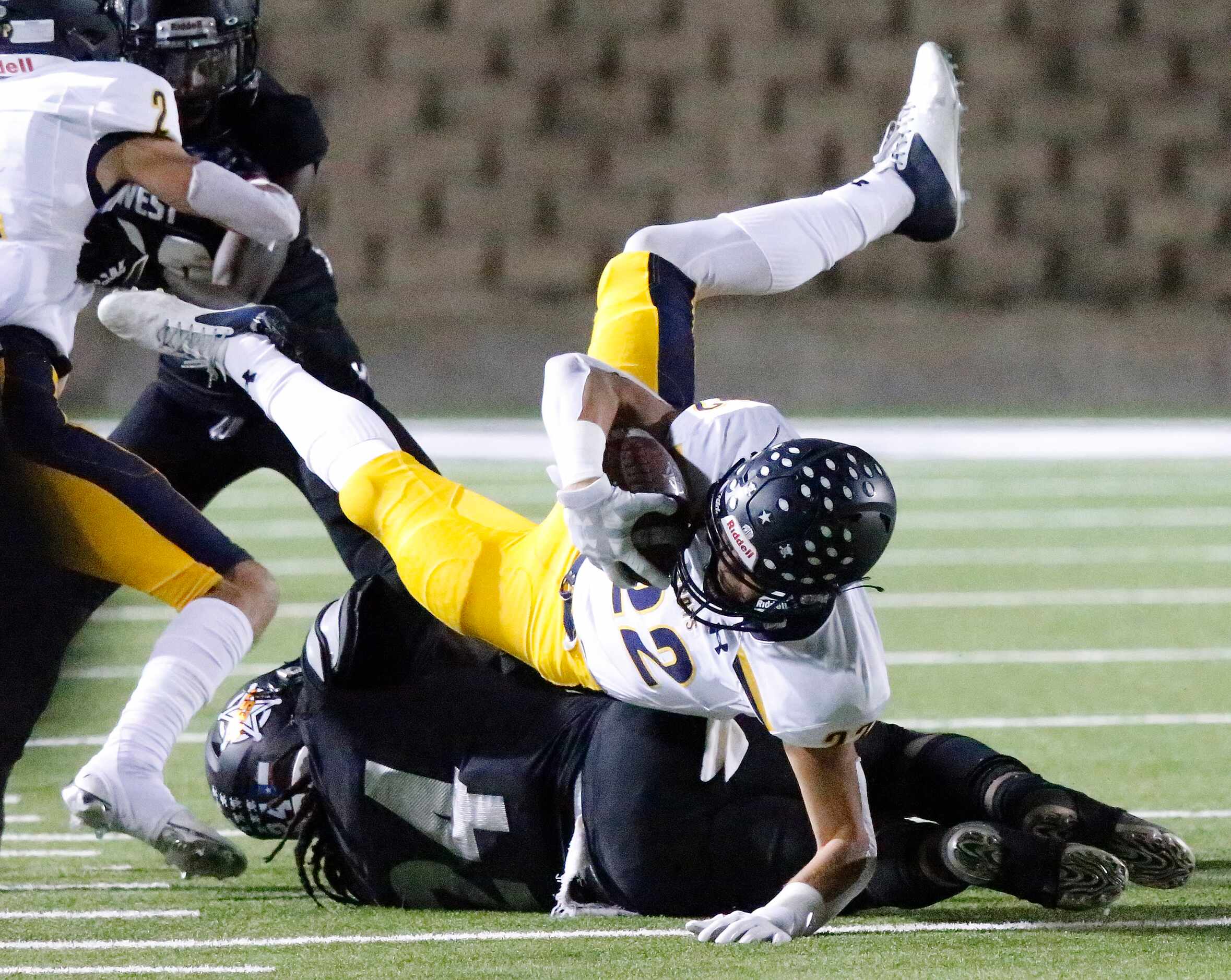 Highland Park High School wide receiver Luke Rossley (22) is upended by West Mesquite High...