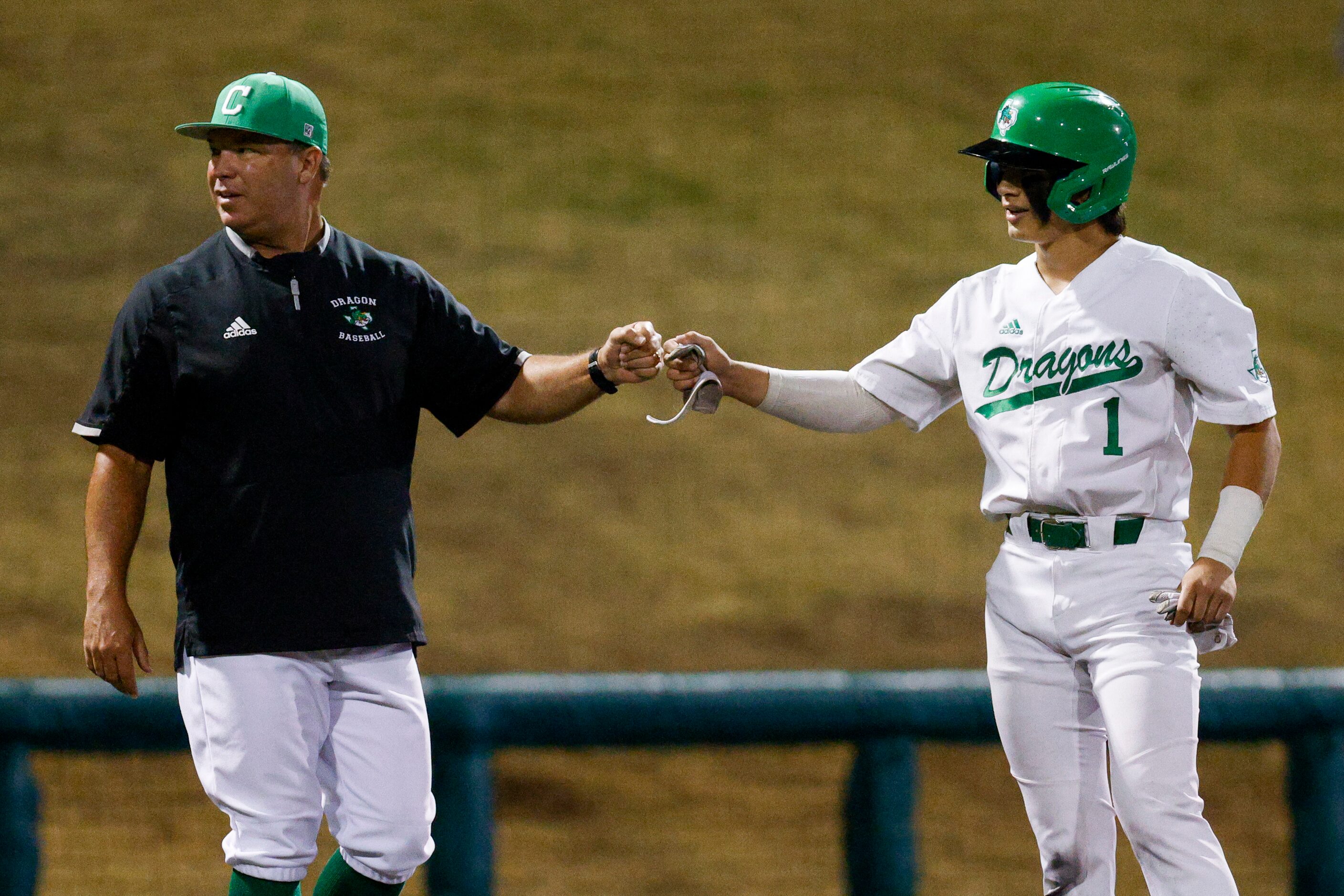 Southlake Carroll shortstop Ethan Mendoza (1) fist bumps head coach Larry Vucan after...