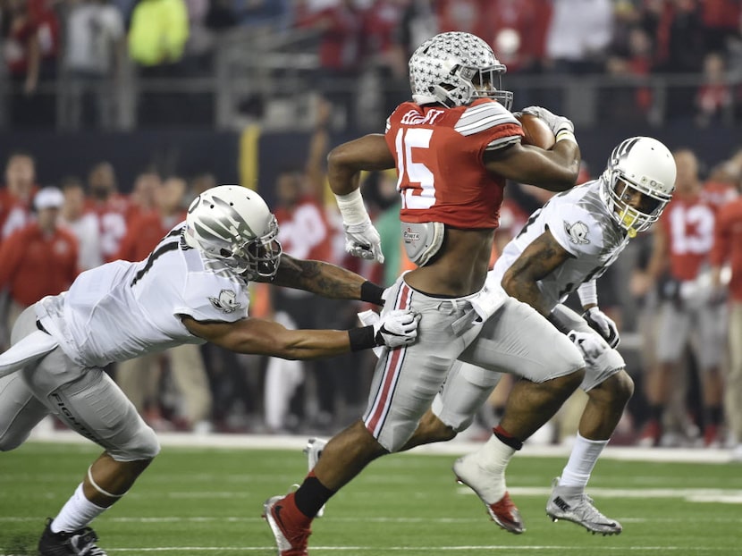 Ohio State Buckeyes running back Ezekiel Elliott (15) gets out of a tackle by a Oregon Ducks...