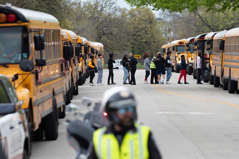 Arlington Police officers block a street as Lamar High School students and faculty are...