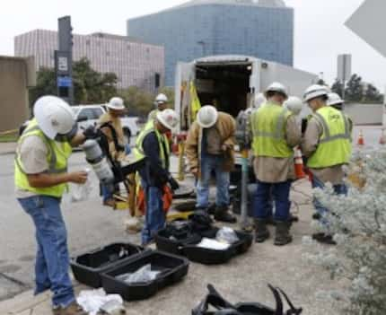  Oncor workers repair an electrical vault after a fire Wednesday morning. (David Woo/Staff...