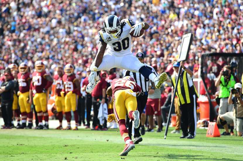 LOS ANGELES, CA - SEPTEMBER 17: Todd Gurley #30 of the Los Angeles Rams leaps over Bashaud...