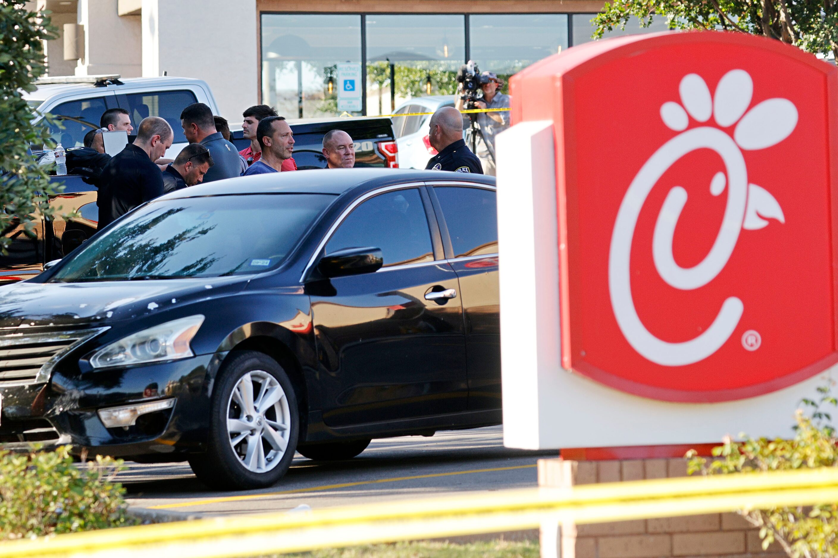 Police investigate in front of a Chick-fil-A at the scene of a shooting, Wednesday, June 26,...