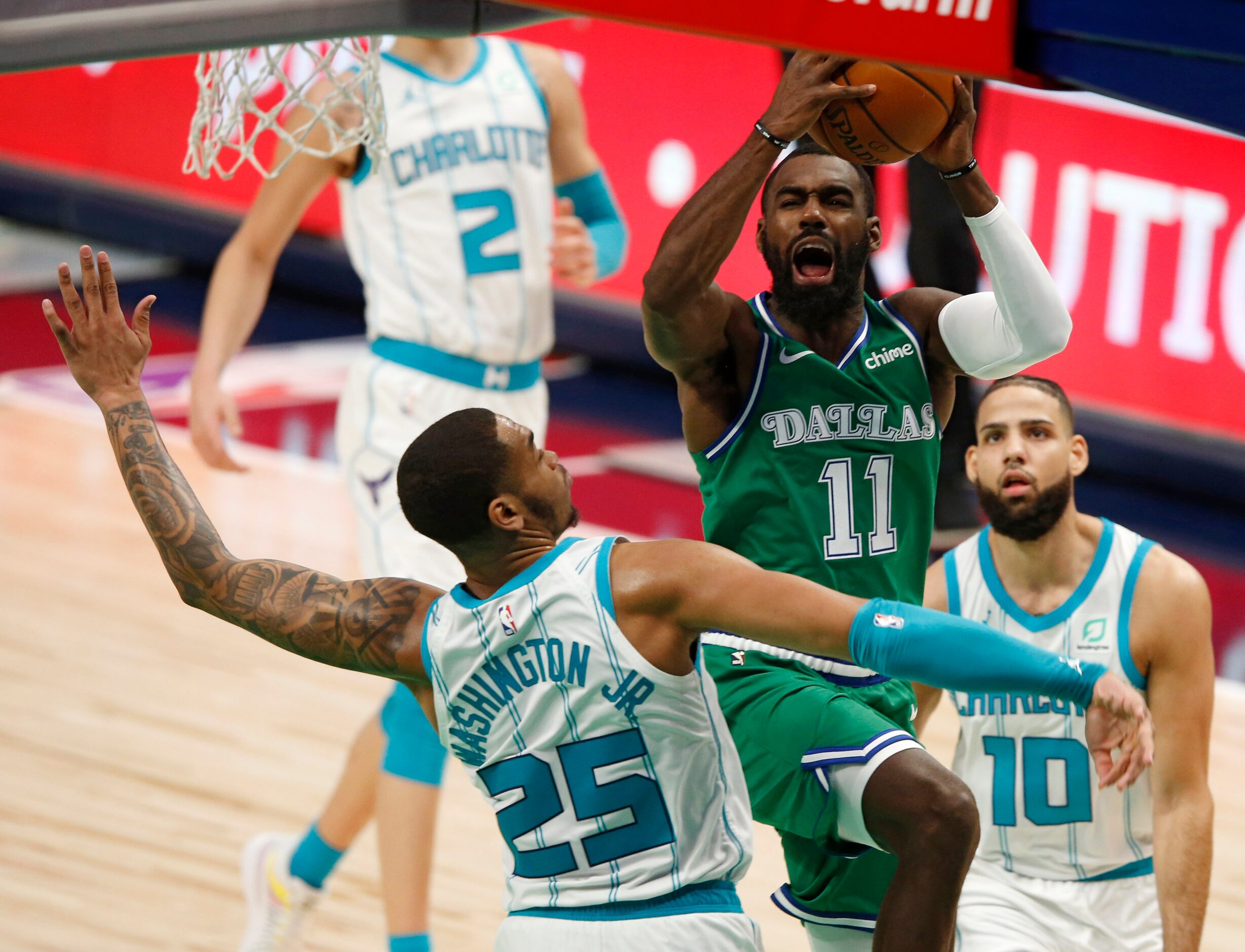 Dallas Mavericks guard Tim Hardaway Jr. (11) attempts a shot as he is defended by Charlotte...