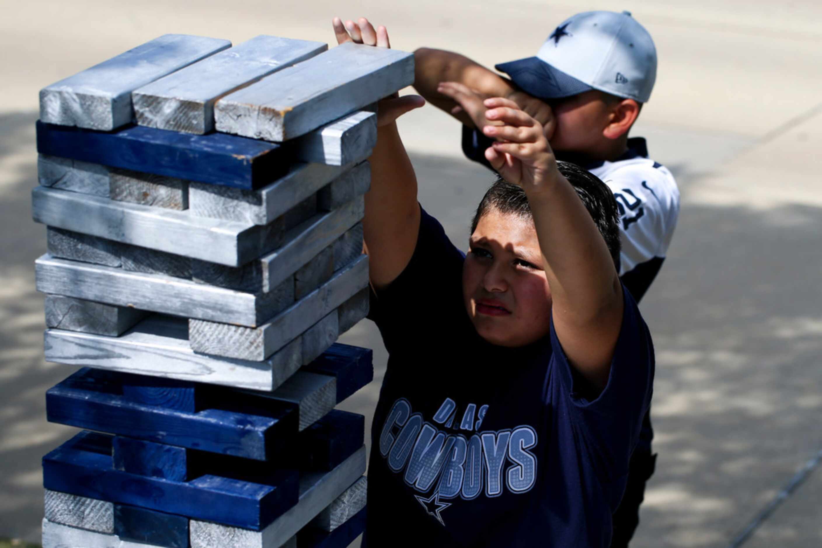 Nevaeh Cruz 13 garland, and Joseph Morales 11, play a game of Jenga as they tailgate with...