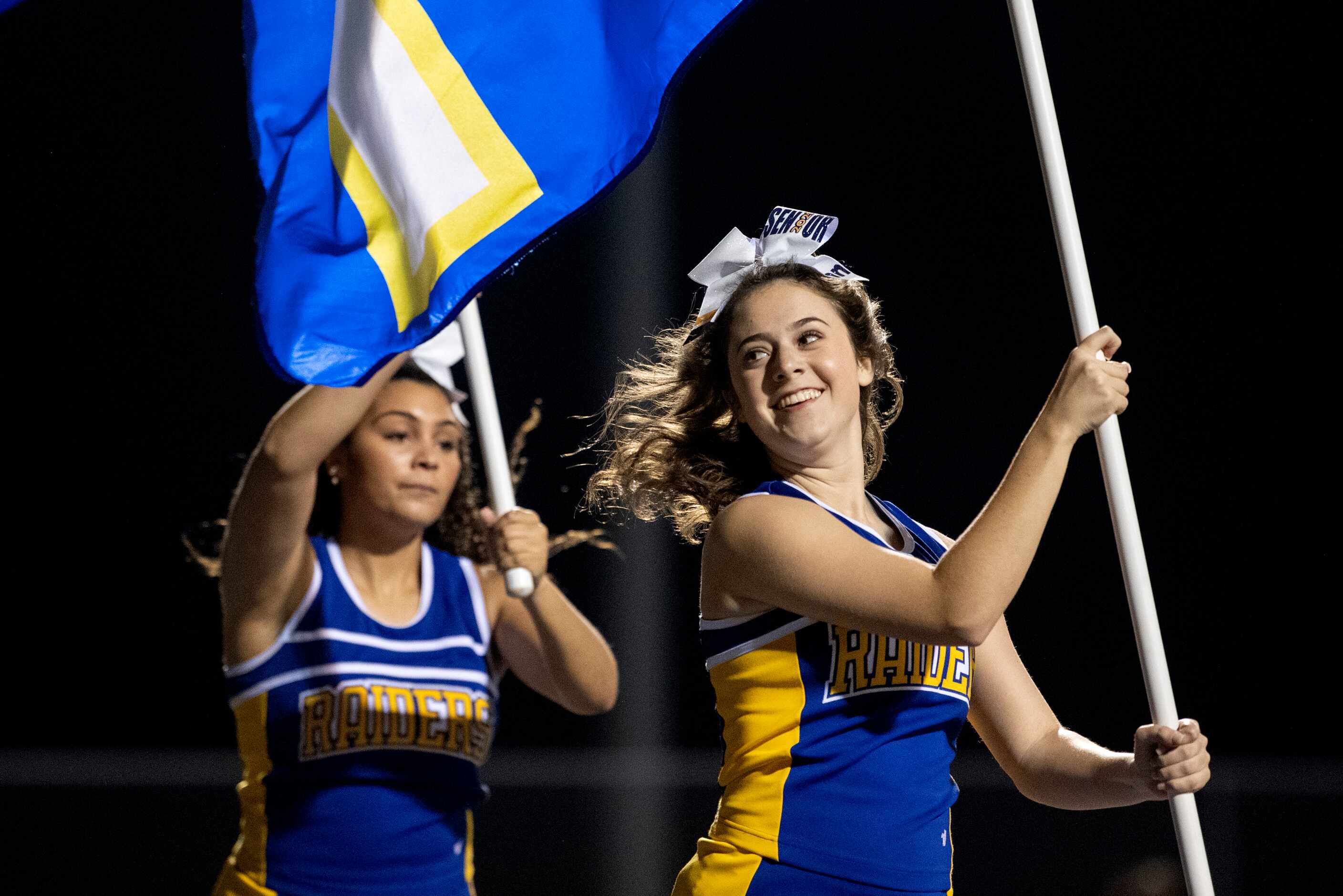 Sunnyvale cheerleaders run flags across the end zone after a touchdown in the first half of...