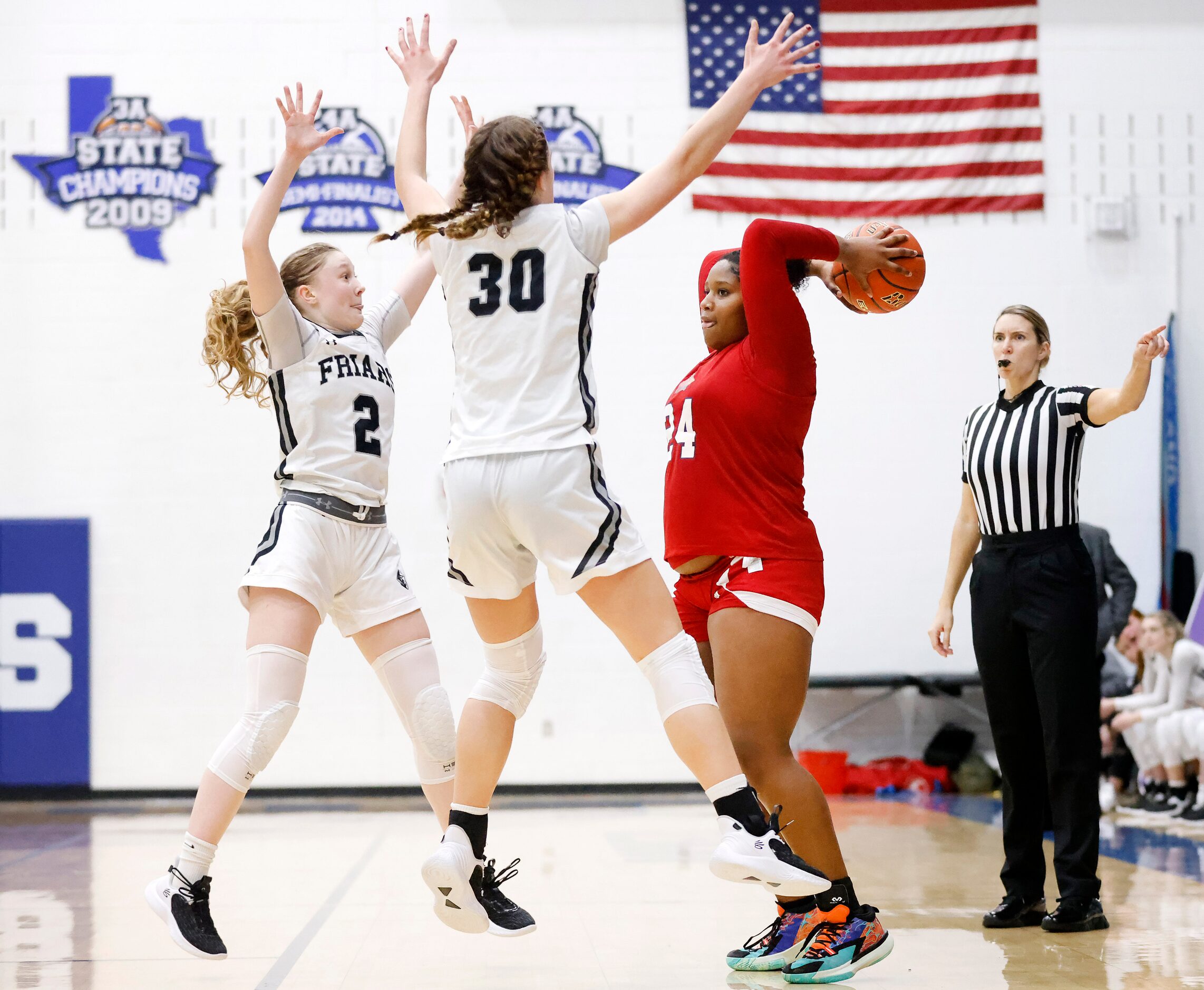 John Paul II forward Taylor Haggan (24) is pressured by Bishop Lynch’s Maddie Heiss (2) and...