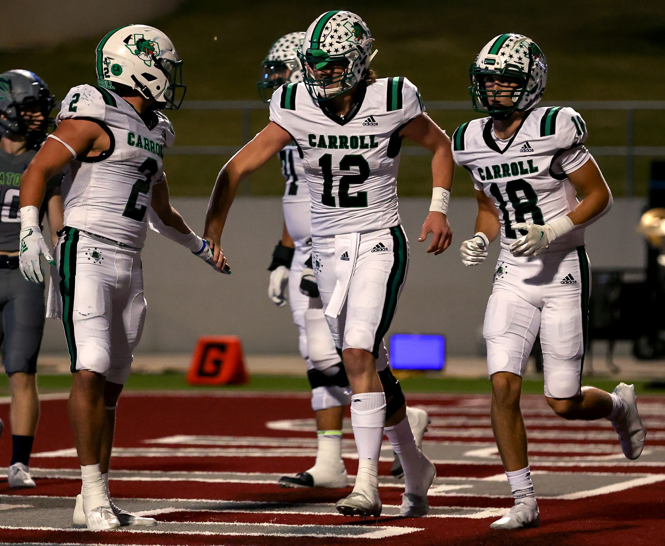 Southlake Carroll quarterback Kaden Anderson (12) is greeted by running back Owen Allen (2)...