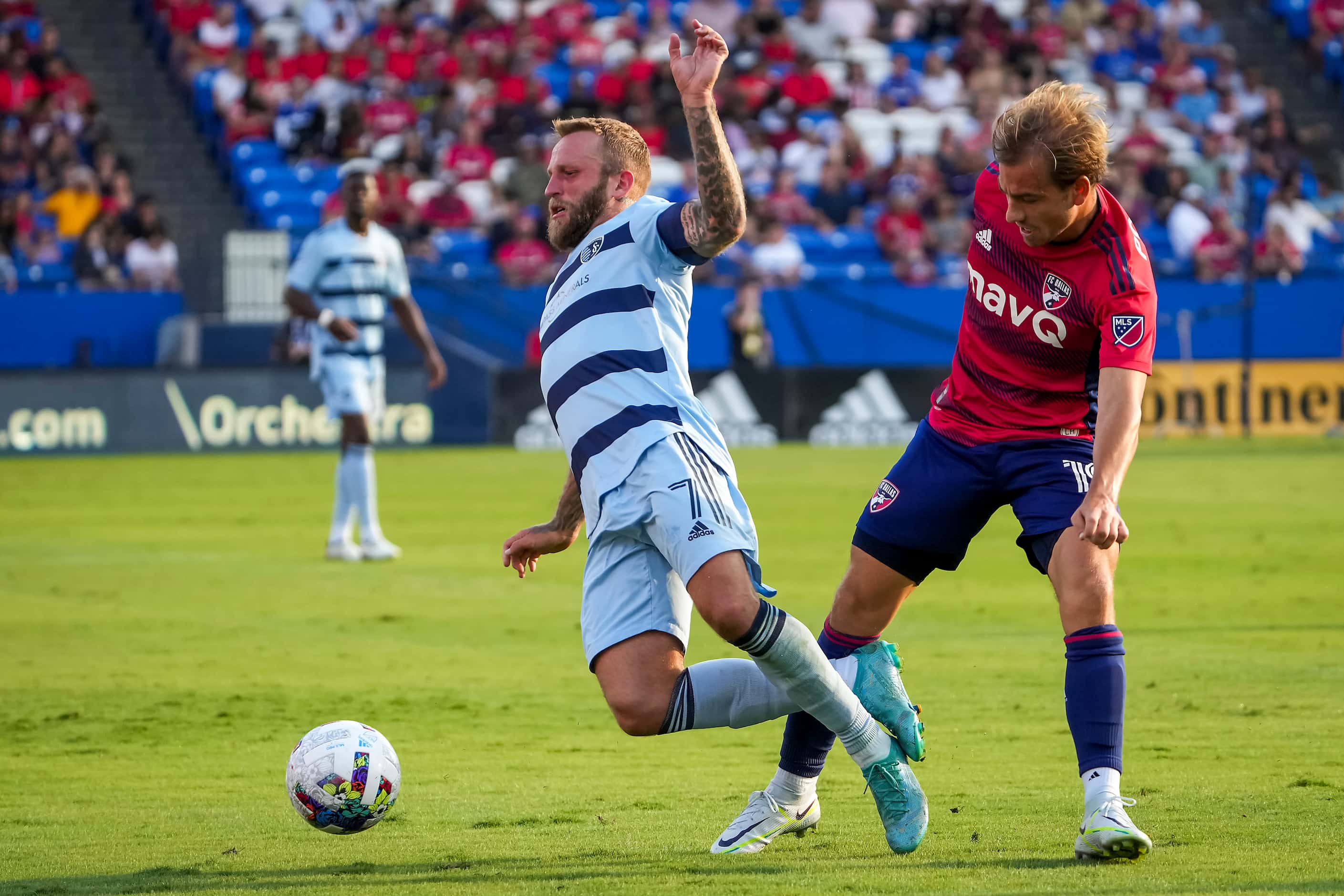 Sporting Kansas City forward Johnny Russell (7) is tripped up by FC Dallas midfielder Paxton...