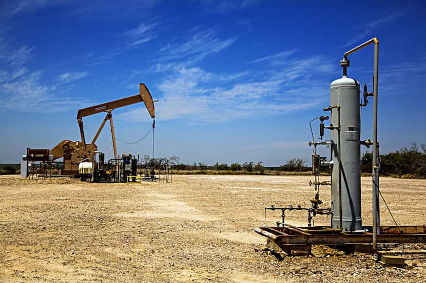 File photo shows an oil pumpjack working in the background by natural gas machinery in Webb...