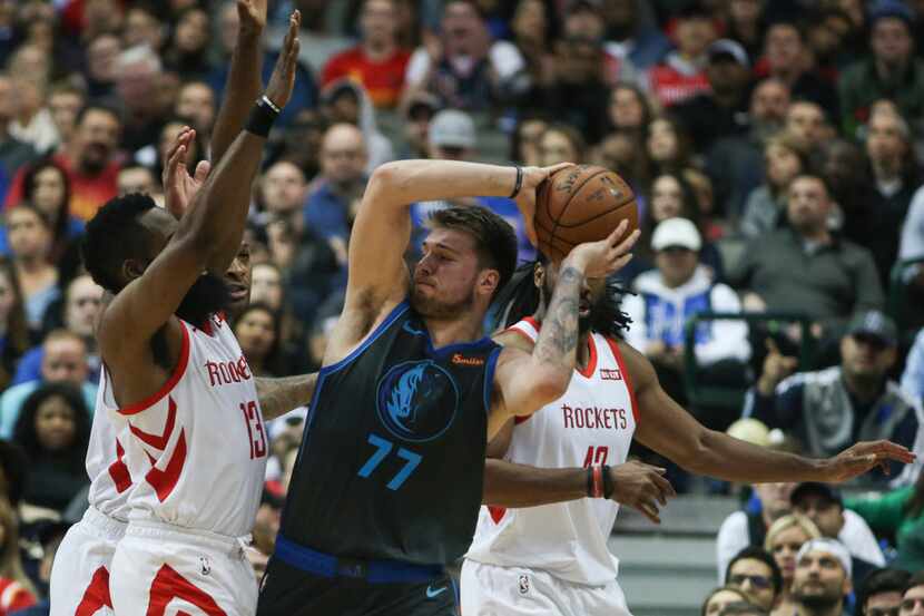 Dallas Mavericks forward Luka Doncic (77) works to get a pass around Houston Rockets guard...