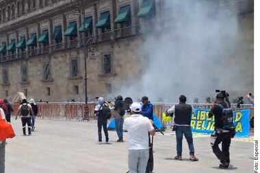 Manifestantes, presuntamente normalistas de Ayotzinapa, lanzan petardos a Palacio Nacional...